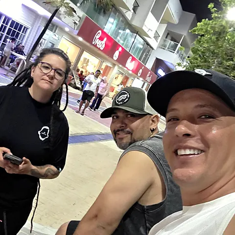 Selfie en una calle de San Andrés: una makara con la camiseta negra del club y dos amigos con gorra
